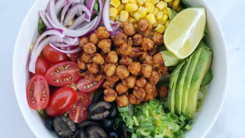 Chickpea Taco Salad is an easy vegan dish that comes together with seasoned garbanzo beans and your favorite taco toppings piled high on a bed of greens.