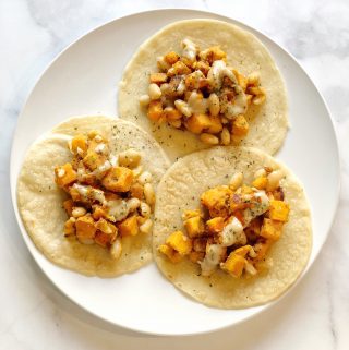 Sweet potato and white beans drizzled in lemon tahini dressing folded up in homemade tortillas will take your taco nights to the next level.