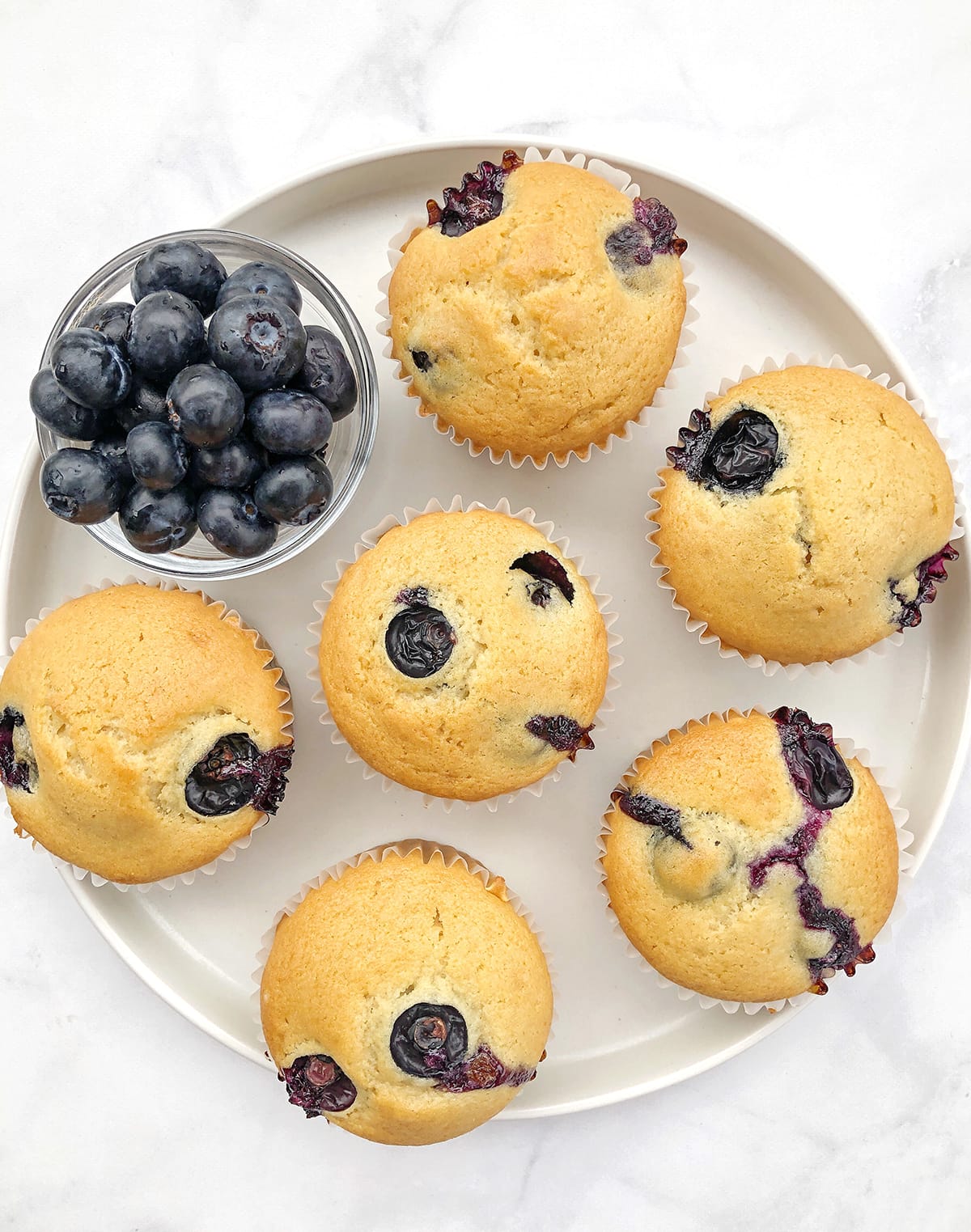 Dairy-free-blueberry-muffins-on-a-plate-with-extra-fresh-blueberries