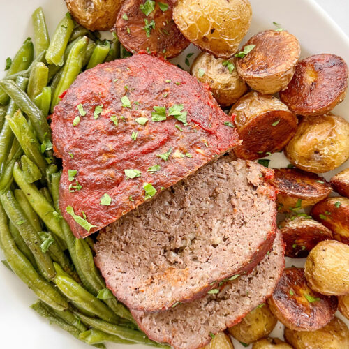 baked ground beef meatloaf with green beans and potatoes.