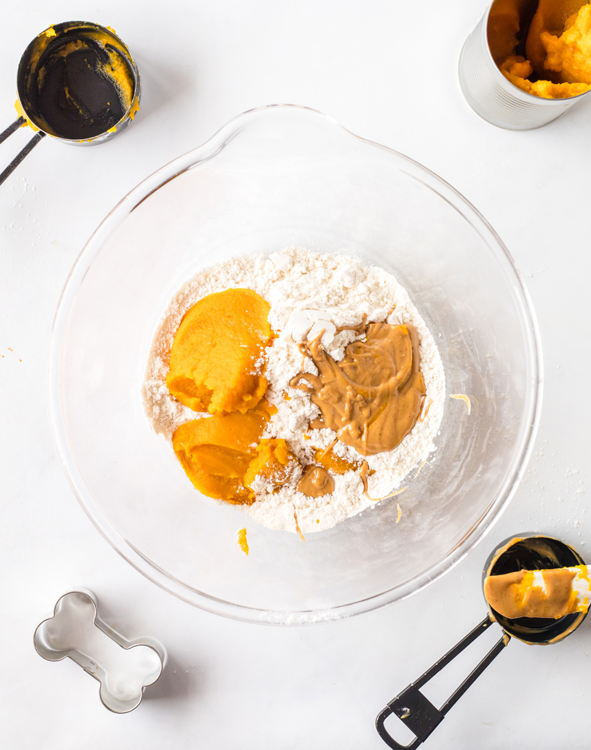 Flour, pumpkin puree, and peanut butter added to a mixing bowl