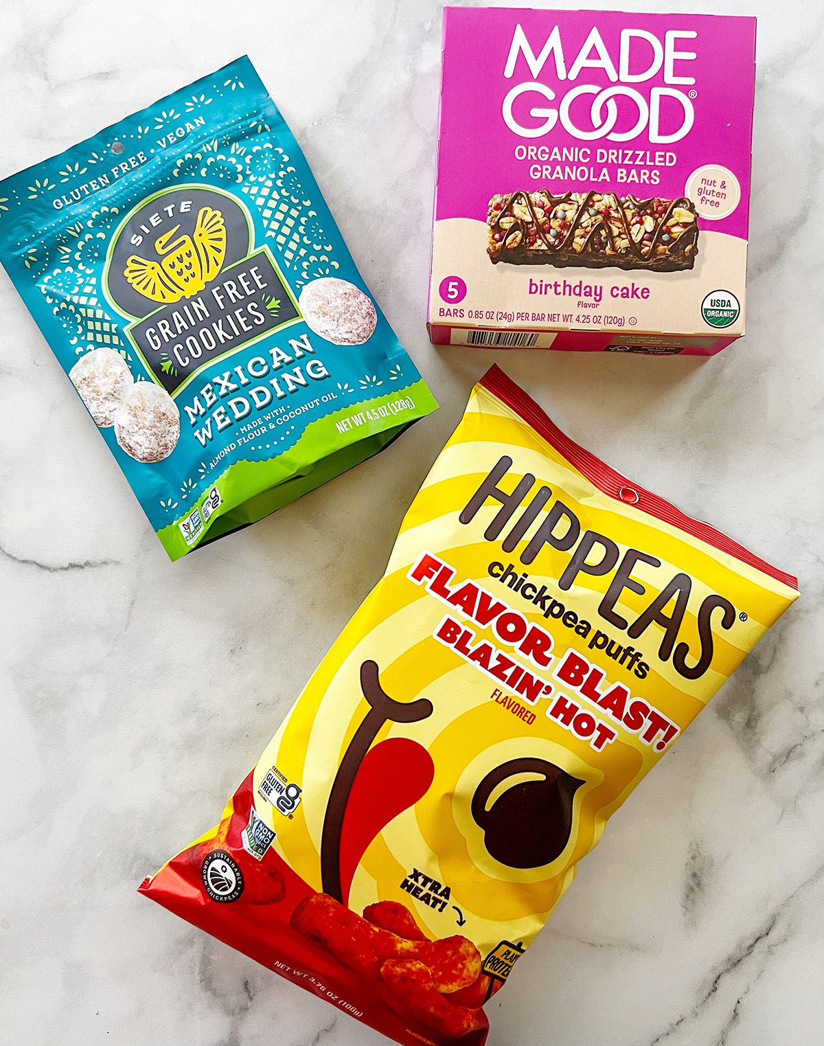 Hippeas chickpea puffs, MadeGood granola bars, and Siete cookies