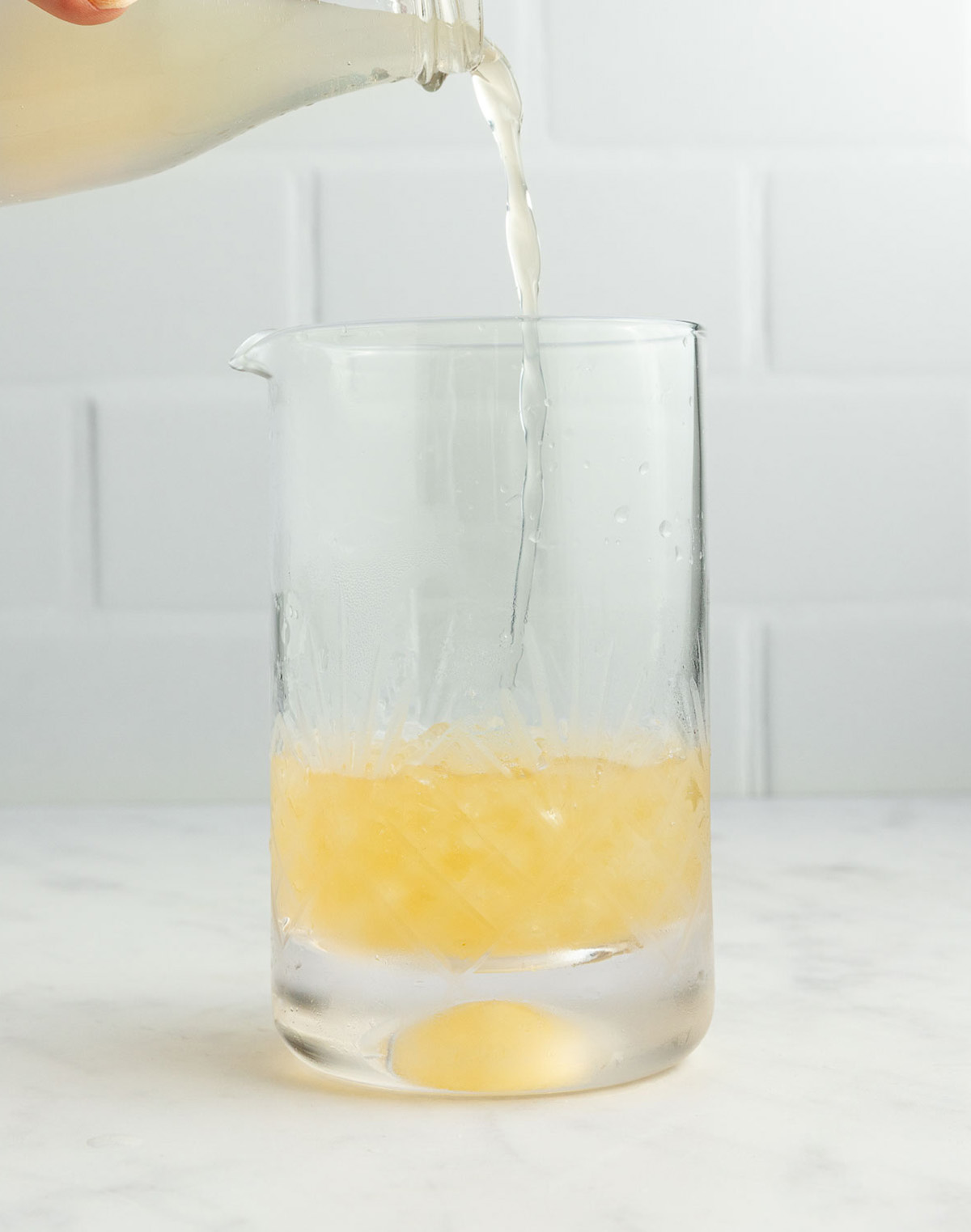 Pouring lime juice into mixing glass