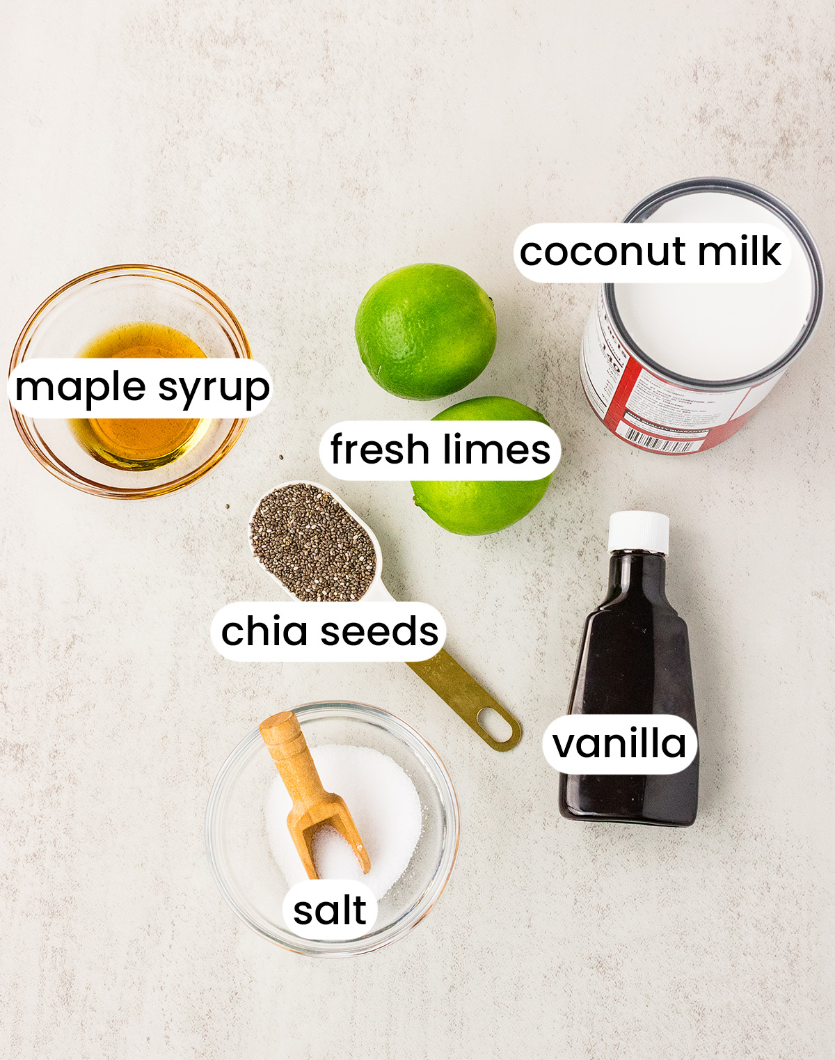 Ingredients for key lime pie chia pudding including chia seeds, coconut milk, fresh limes, maple syrup, and vanilla