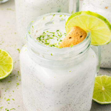 Key lime chia pudding in a glass jar topped with lime slice, coconut, and graham cracker