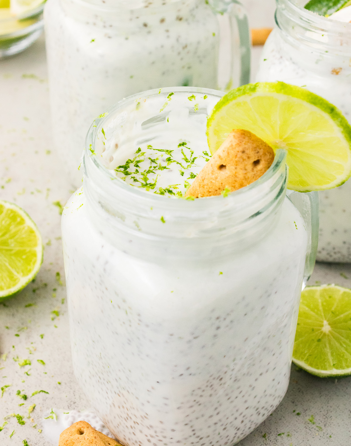 Key lime chia pudding in a glass jar topped with lime slice, coconut, and graham cracker