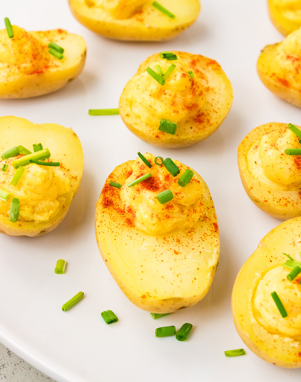 Close up of eggless deviled potatoes with creamy filling and chives.