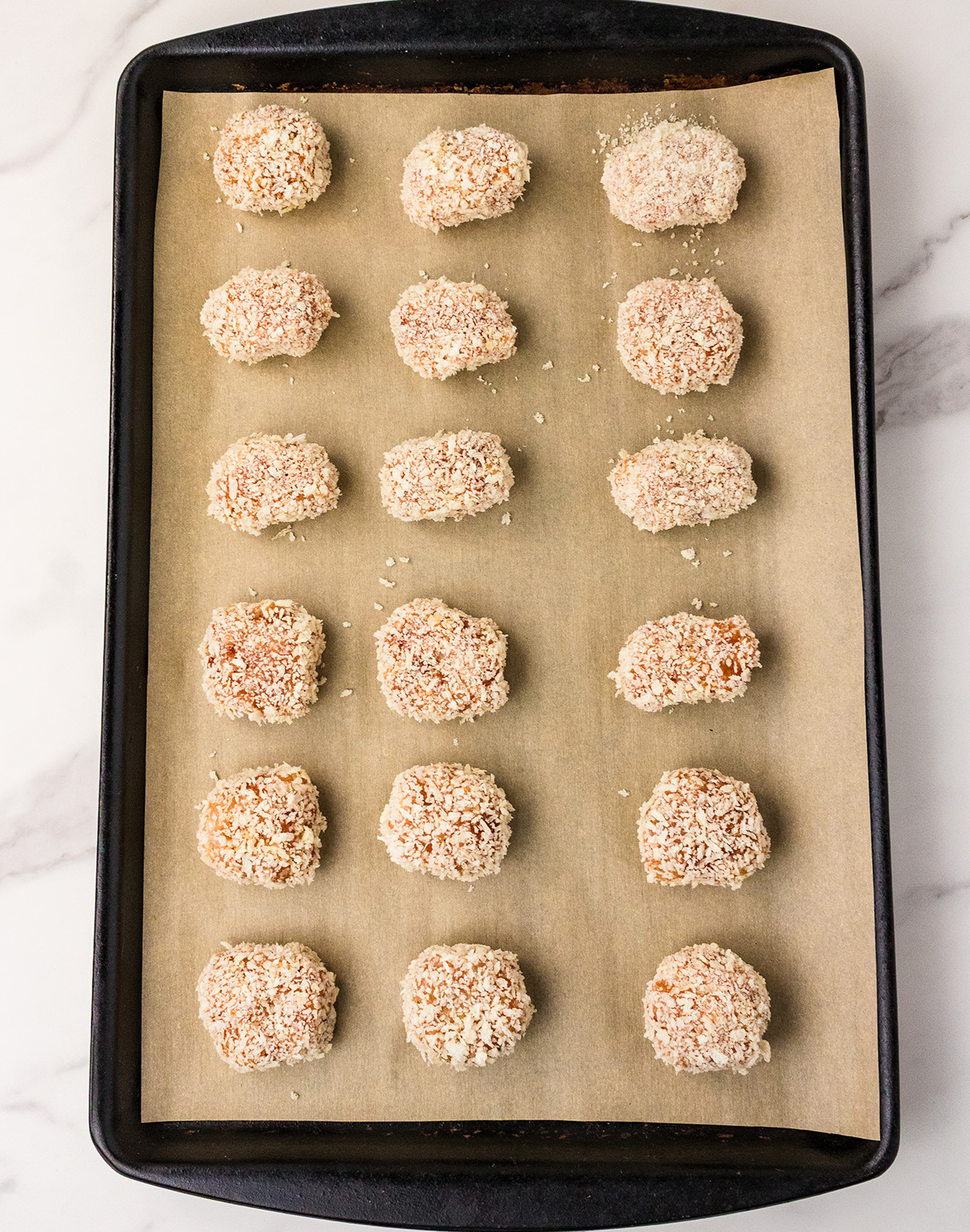 panko breadcrumb coated chicken tenders on baking sheet